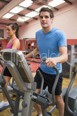 Man and woman stepping on a step machine