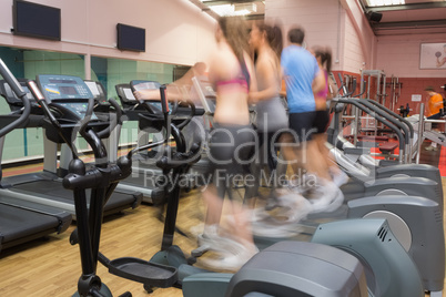 People working out on on step machines at speed