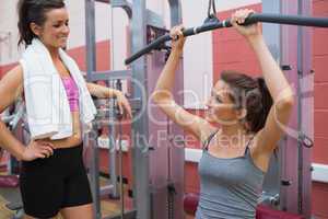 Woman talks to friend using weight machine