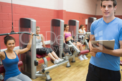 Trainer in weights room with women