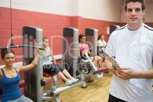 Trainer teaching women in weights room