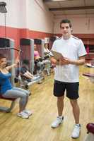Man teaching his fitness class in weights room