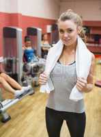 Woman with towel around neck in weights room