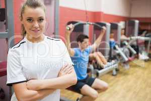 Woman with arms crossed standing in a fitness studio