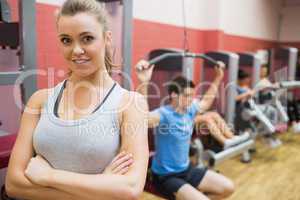 Smiling female trainer with arms crossed