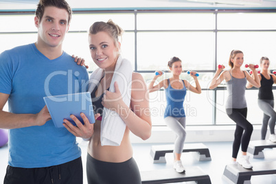 Trainer and woman smiling together during aerobics class