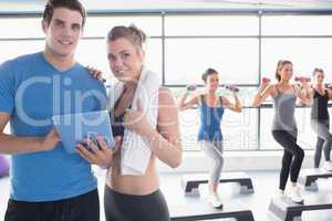 Trainer and woman smiling together during aerobics class