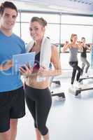 Woman and trainer looking at timetable in aerobics class