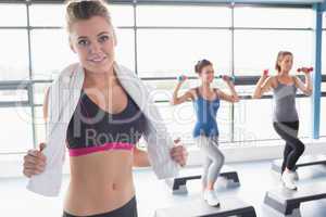 Woman smiling at front of aerobics class