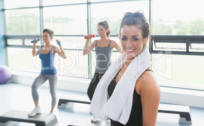 Woman with towel around neck at aerobics class