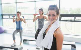 Woman with towel around neck at aerobics class
