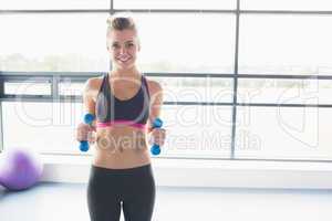 Woman lifting weights in fitness studio