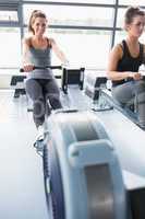 Two people training on row machines