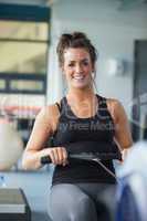 Cheerful woman training on row machine