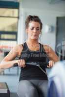 Woman training hard on row machine