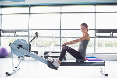 Happy woman training on row machine