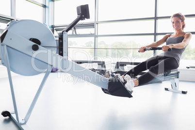 Smiling woman training on row machine