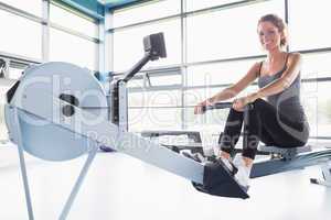 Woman training happily on row machine