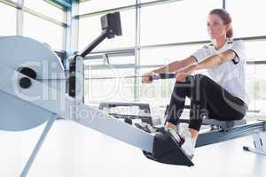Concentrating  woman training on row machine