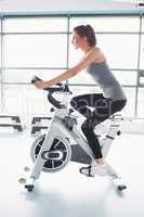 Woman energetically riding exercise bike
