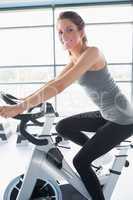 Smiling woman riding an exercise bike