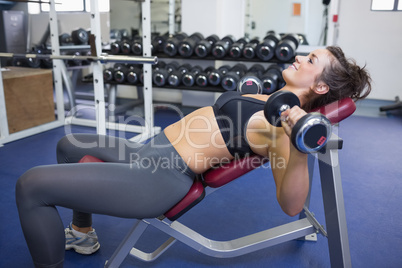 Woman training with weights while lying