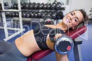 Smiling woman training with weights