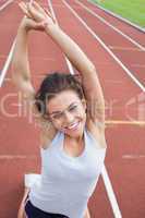 Woman on a track stretching her arms