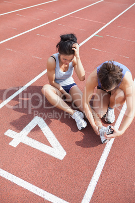 Woman caring about runner with sports injury