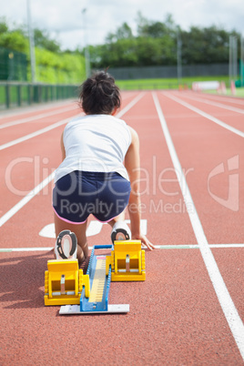Woman at starting blocks on track