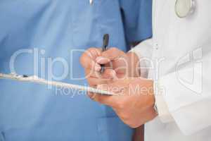 Doctor writing on clipboard