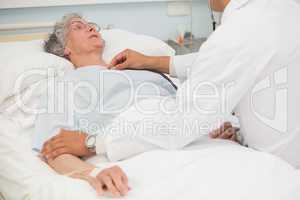 Doctor listening to heart beat of elderly patient