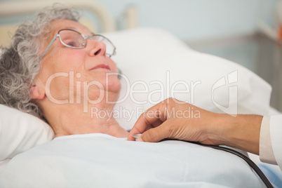 Doctor using stethoscope on elderly patient
