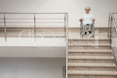 Elderly lady in wheelchair at top of stairs