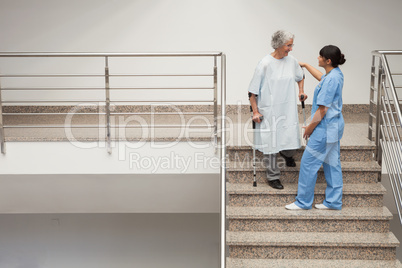 Nurse helping elderly lady get down stairs