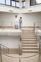 Nurse and doctor talking at top of stairwell