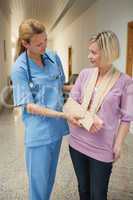 Nurse touching  broken arm of patient