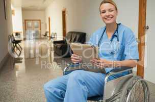 Smiling nurse in a wheelchair holding a folder
