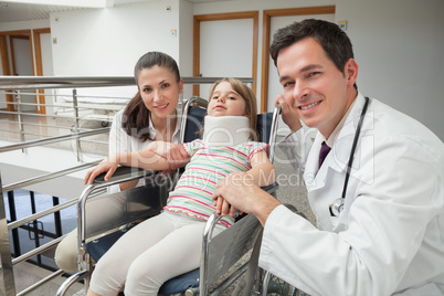 Smiling doctor, mother and her child in wheelchair