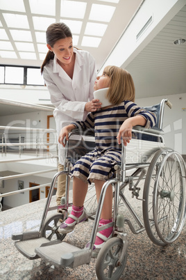 Doctor talking to child with neckb race in wheelchair