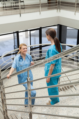 Two nurses standing opposite each other in the stairwell