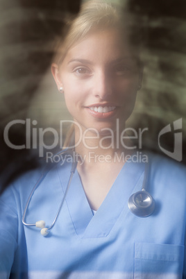 Young female doctor with blurred x-ray background