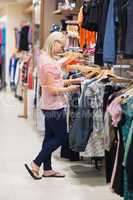 Woman searching for clothes standing in a shop
