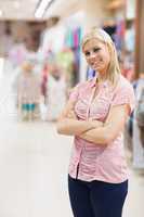 Woman standing in a shop arms crossed