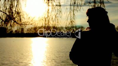 silhouette lady near lake