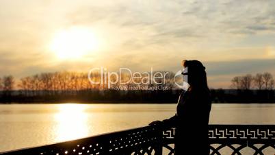 silhouette of lady near lake, sunset
