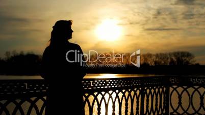 silhouette of lady near lake, sunset