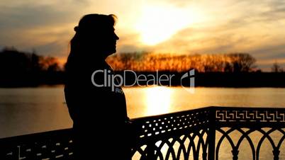 silhouette of lady near lake, sunset