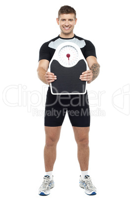 Attractive athlete showing weighing scale