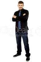 Handsome young male executive with folded arms